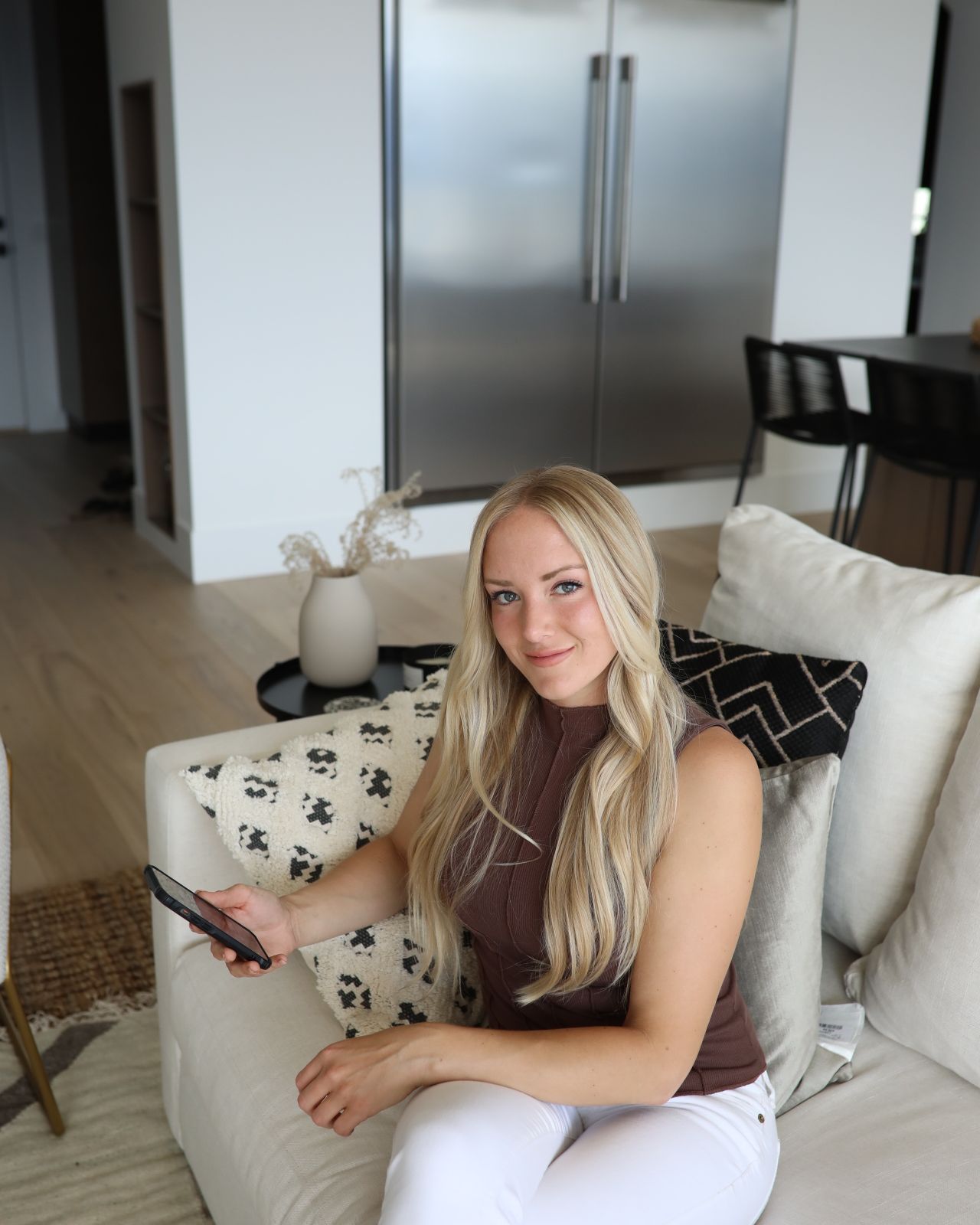 Emily, founder of Noumena House, at home with her phone